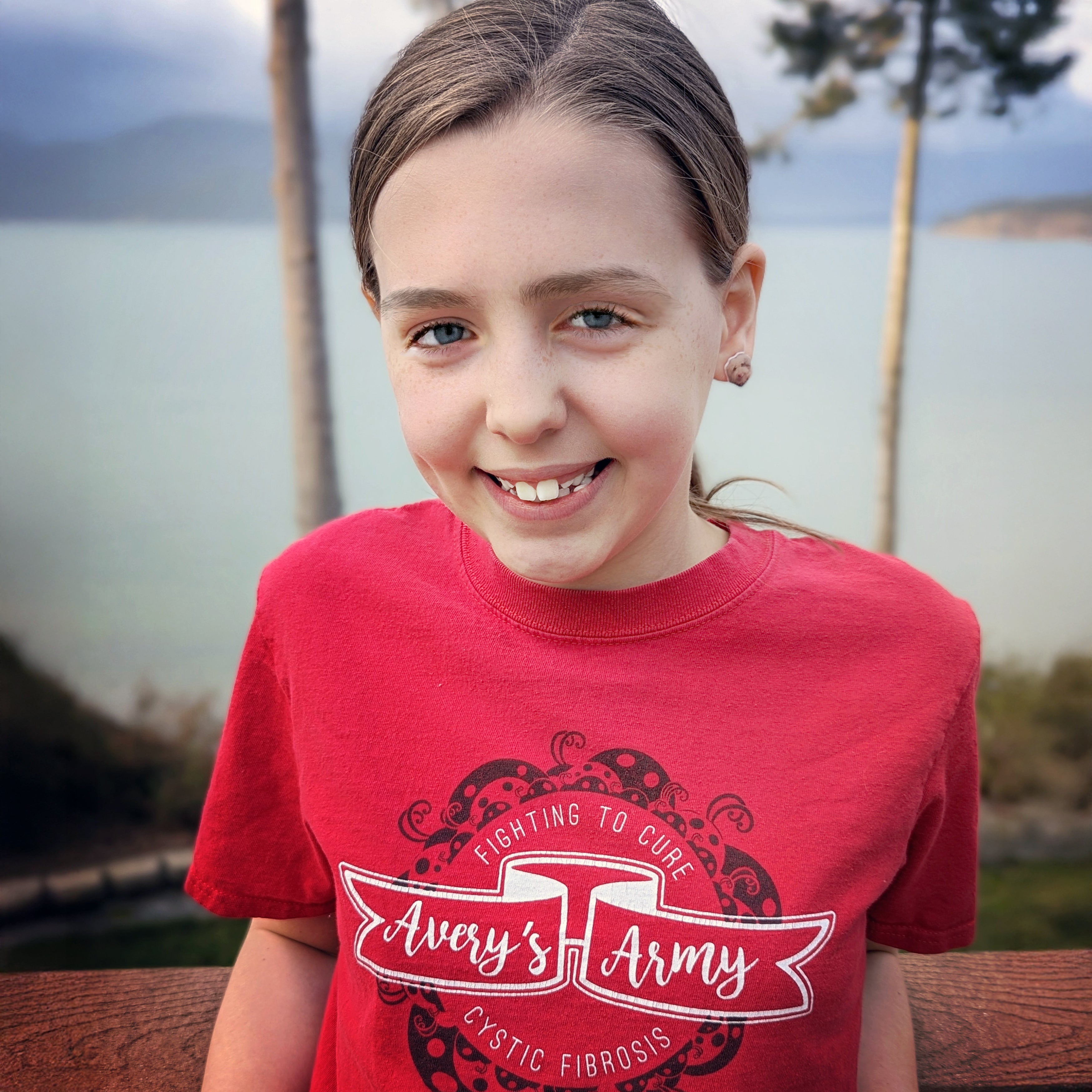 Avery wearing a red Avery's Army Fighting to Cure Cystic Fibrosis shirt