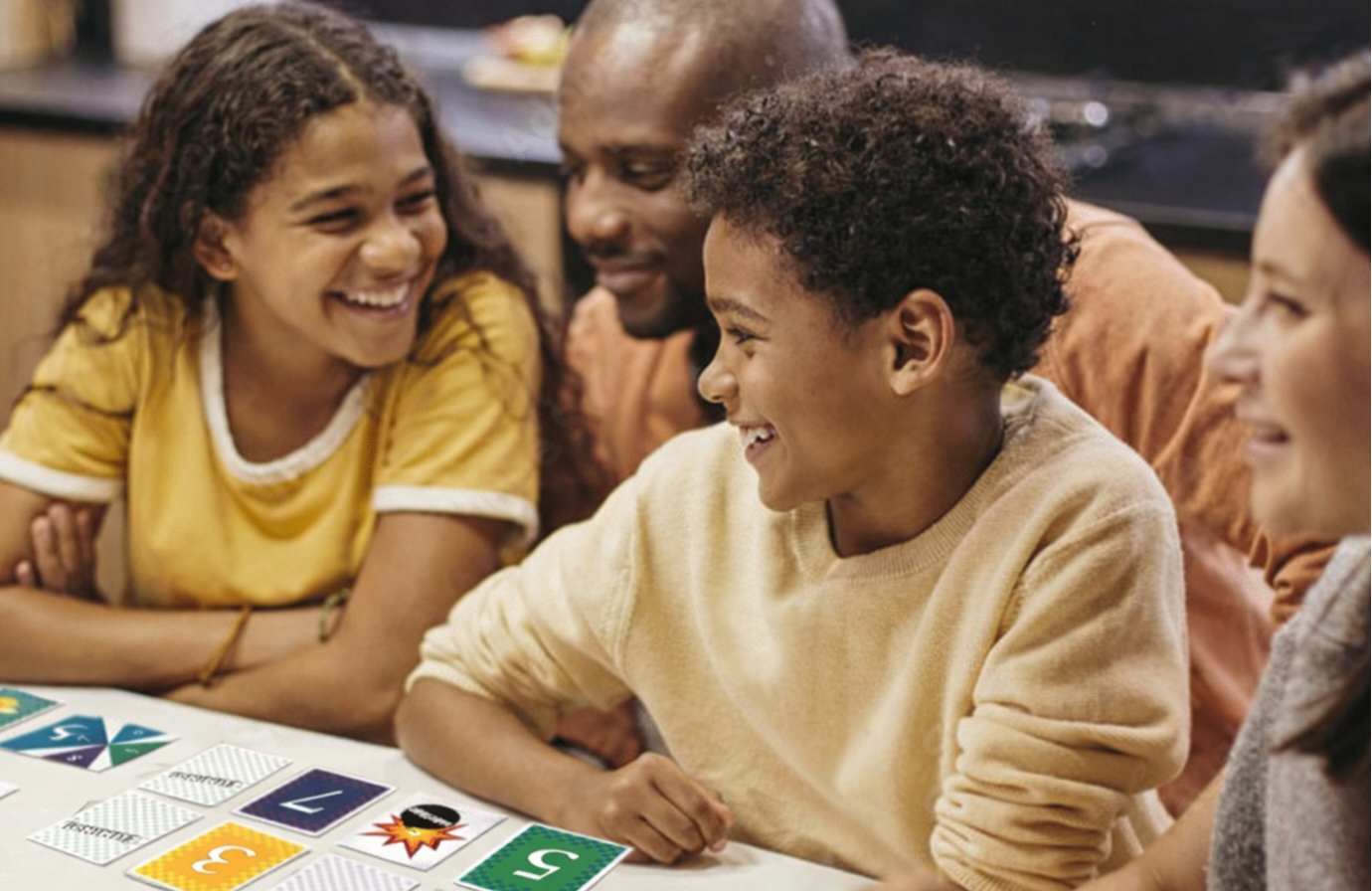 Kids and parents play Elimino at a table